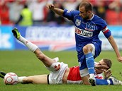 Sl�vistick� fotbalista Petr Janda v souboji s �steck�m kapit�nem Luk�em Dvo��kem.