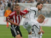 Žižkovský Richard Kalod (vlevo) se marně pokouší prosadit proti obráncům Hradce.