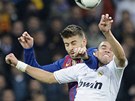 FAUL ZA �LUTOU KARTU. Barcelonsk� obr�nce Gerard Piqu� trefuje loktem Pepeho,