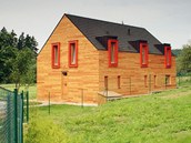 Atypické vchodové dveře, které dokonale splývají s dřevěným obkladem fasády,...