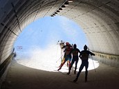 SVĚTLO NA KONCI TUNELU. Lyžaři projíždějí tunelem během závodu štafet. SVĚTLO NA KONCI TUNELU. Lyžaři projíždějí tunelem během závodu štafet.