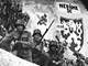Zn�m� propaga�n� pohlednice z kv�tna 1938 doned�vna tajila, kdo a kde vytvo�il vlasteneck� motiv na skaln�m reli�fu v pozad�. Vytesali jej z�lo�n�ci z p��ho pluku 152 v severo�esk�ch Podbo�anech.