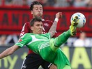 Fotbalista Mario Mandukic z Wolfsburgu (v zelen�m) odkop�v� m�� v bundesligov�m