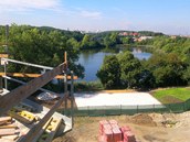 Pohled na rybník z balkonu rozestavěného bytu, součastí nového areálu je i