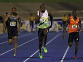 Usain Bolt (uprost�ed) si v Kingstonu b�� pro v�t�zstv� na stometrov� trati.