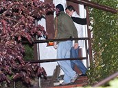 David Rath v doprovodu policist� odch�z� ze sv�ho domku v Hostivici.