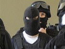Tom� Pitr (t�et� zleva) p�ich�z� v doprovodu policist� na jedn�n� pra�sk�ho