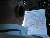 Pilot studuje mapku s pl�nem letu.
