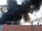 Po��r fotovoltaick�ch panel� na st�e�e skladu ve V�echromech.