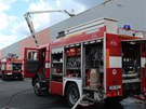 Po��r fotovoltaick�ch panel� na st�e�e skladu ve V�echromech.