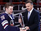 P�EDÁNÍ. Americký kapitán Paul Stastny p�ebírá z rukou Reneho Fasela trofej pro