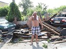 Josef Kobza u trosek střechy ze svého domu. Trámy zavalily i jeho auto (vlevo) Josef Kobza u trosek střechy ze svého domu. Trámy zavalily i jeho auto (vlevo)
