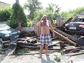 Josef Kobza u trosek střechy ze svého domu. Trámy zavalily i jeho auto (vlevo) Josef Kobza u trosek střechy ze svého domu. Trámy zavalily i jeho auto (vlevo)