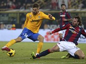 Fernando Llorente z Juventusu Turín zasekl míč, do skluzu jde boloňský obránce Fernando Llorente z Juventusu Turín zasekl míč, do skluzu jde boloňský obránce