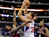 Blake Griffin (uprostřed) z Los Angeles Clippers se snaží prosadit přes bránící... Blake Griffin (uprostřed) z Los Angeles Clippers se snaží prosadit přes bránící...