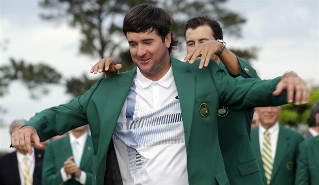 Loňský šampion Adam Scott (vzadu) obléká do zeleného saka pro vítěze golfového... Loňský šampion Adam Scott (vzadu) obléká do zeleného saka pro vítěze golfového...