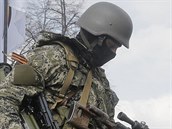 Maskovaný ozbrojený strážce s oranžovo-černou stuhou připnutou na uniformě. Maskovaný ozbrojený strážce s oranžovo-černou stuhou připnutou na uniformě.