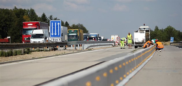 Dělníci pokládají středové panely pro nové provizorní pruhy na modernizovaném... Dělníci pokládají středové panely pro nové provizorní pruhy na modernizovaném...